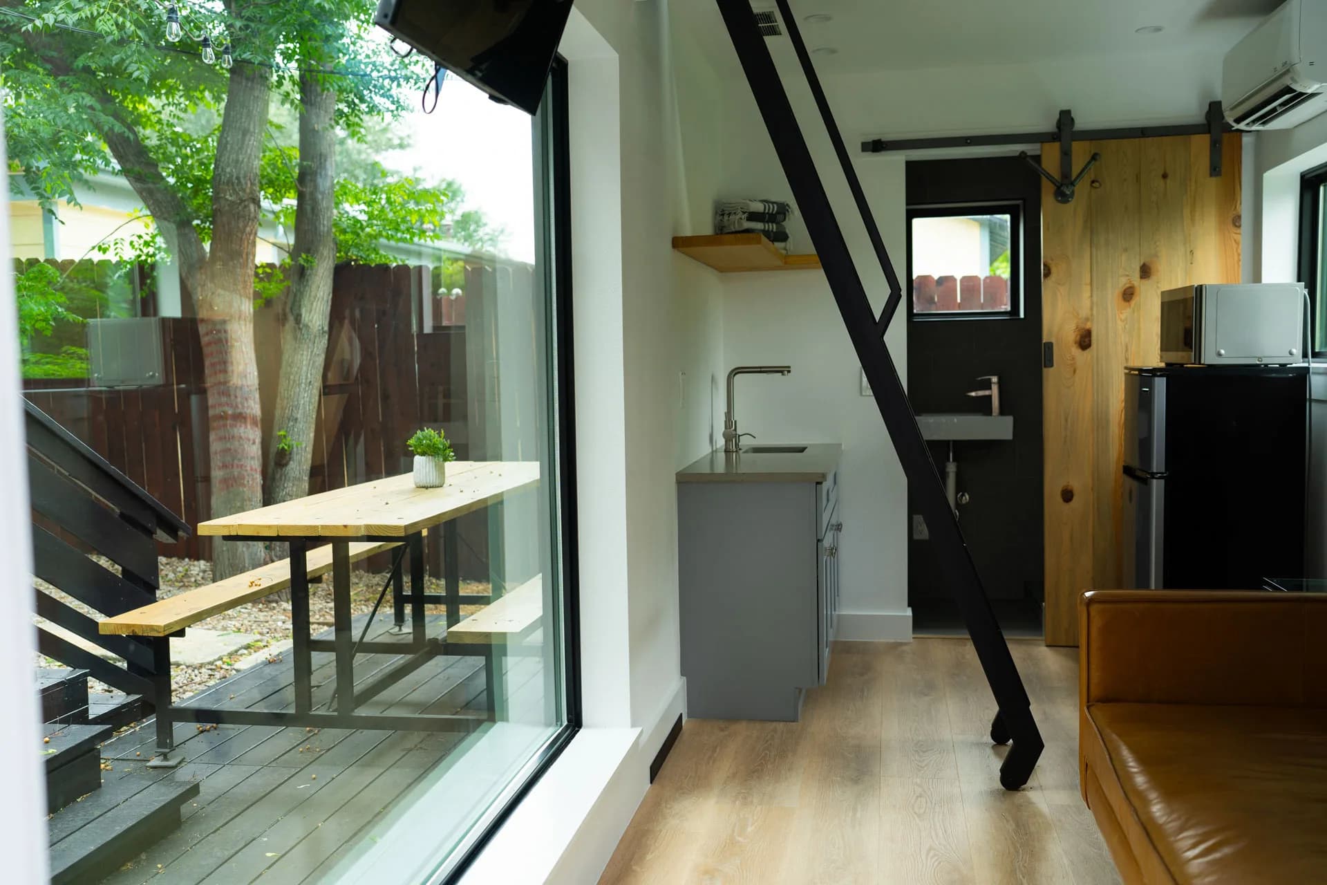 Garden-facing windows and compact kitchen in Domain’s Black Container ADU in East Austin
