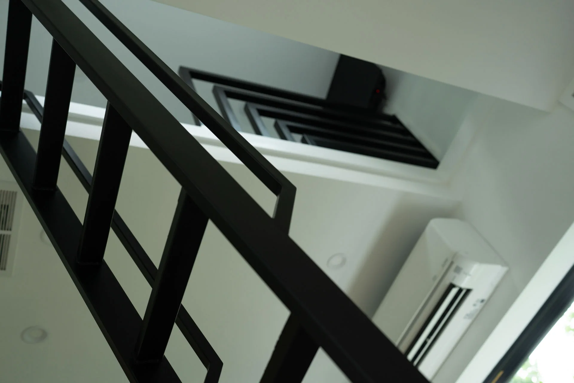 Black metal stair rail and loft opening in Domain’s Black Container ADU