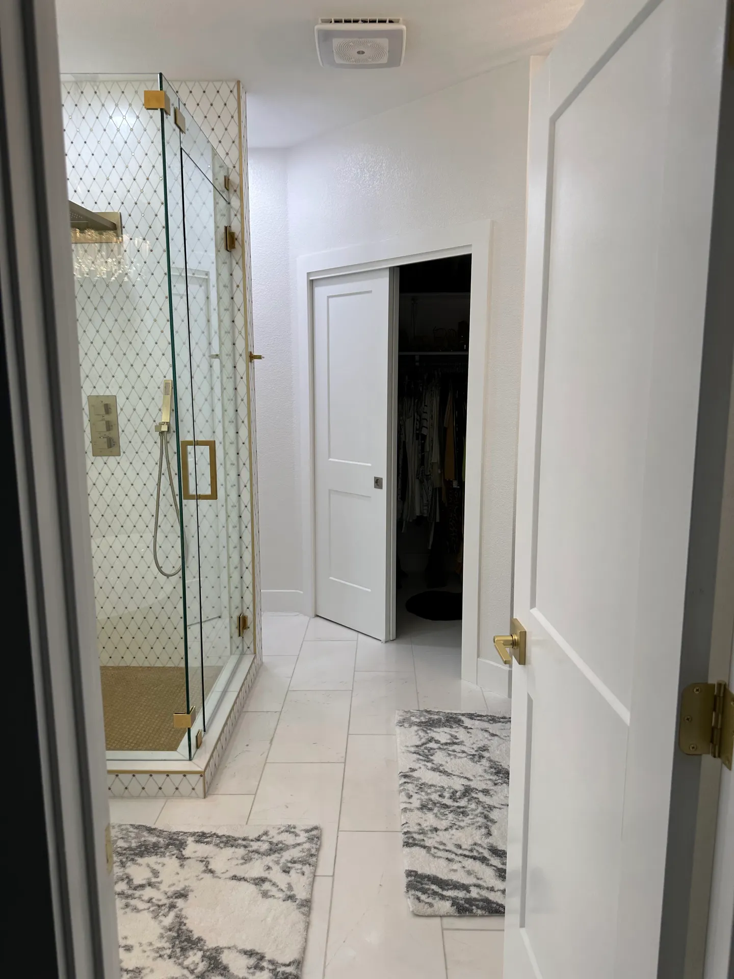 The same view after the remodel, with a frameless glass shower and white tile