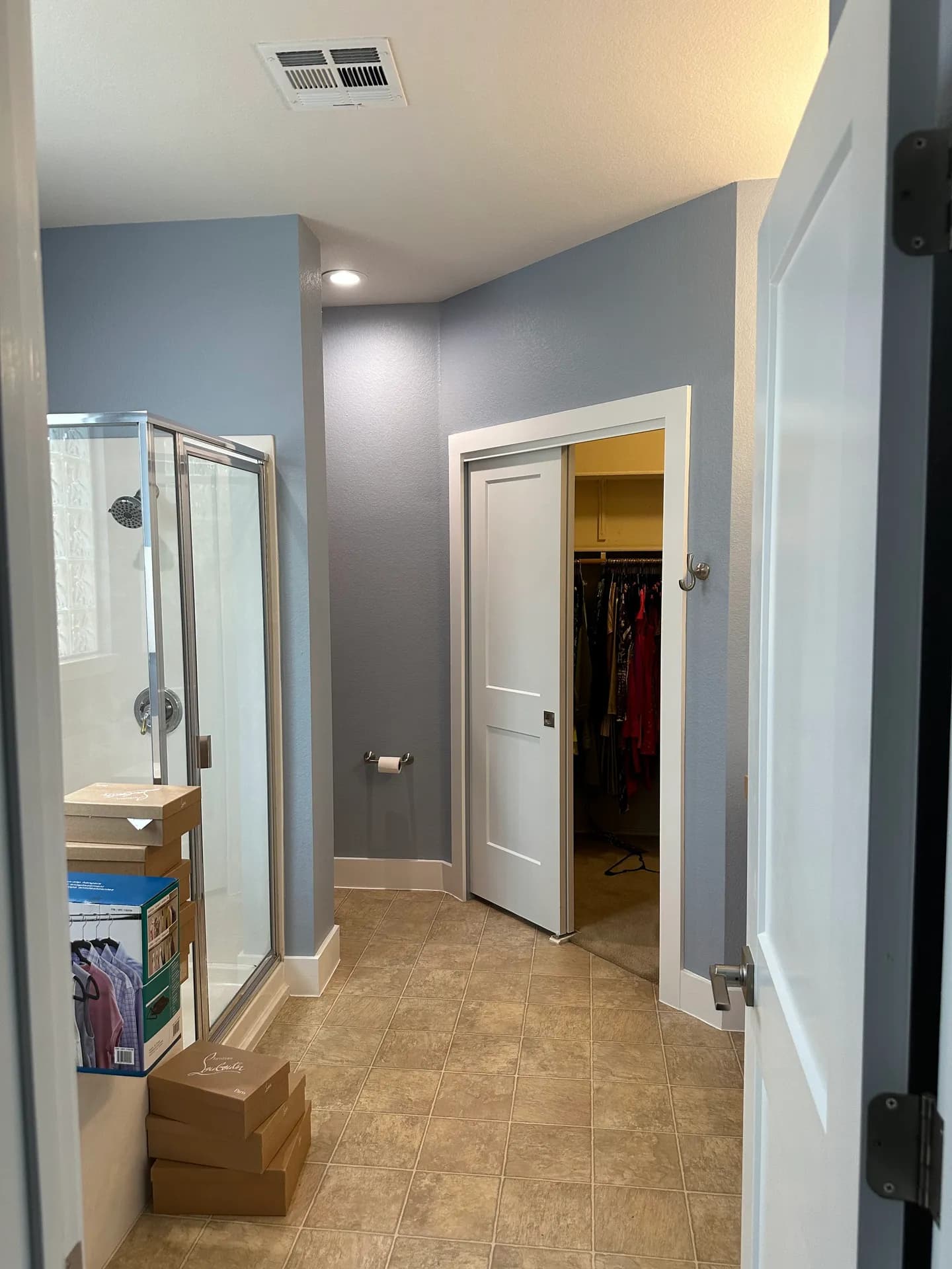 The bathroom before the remodel, with a framed shower and tan floor tile