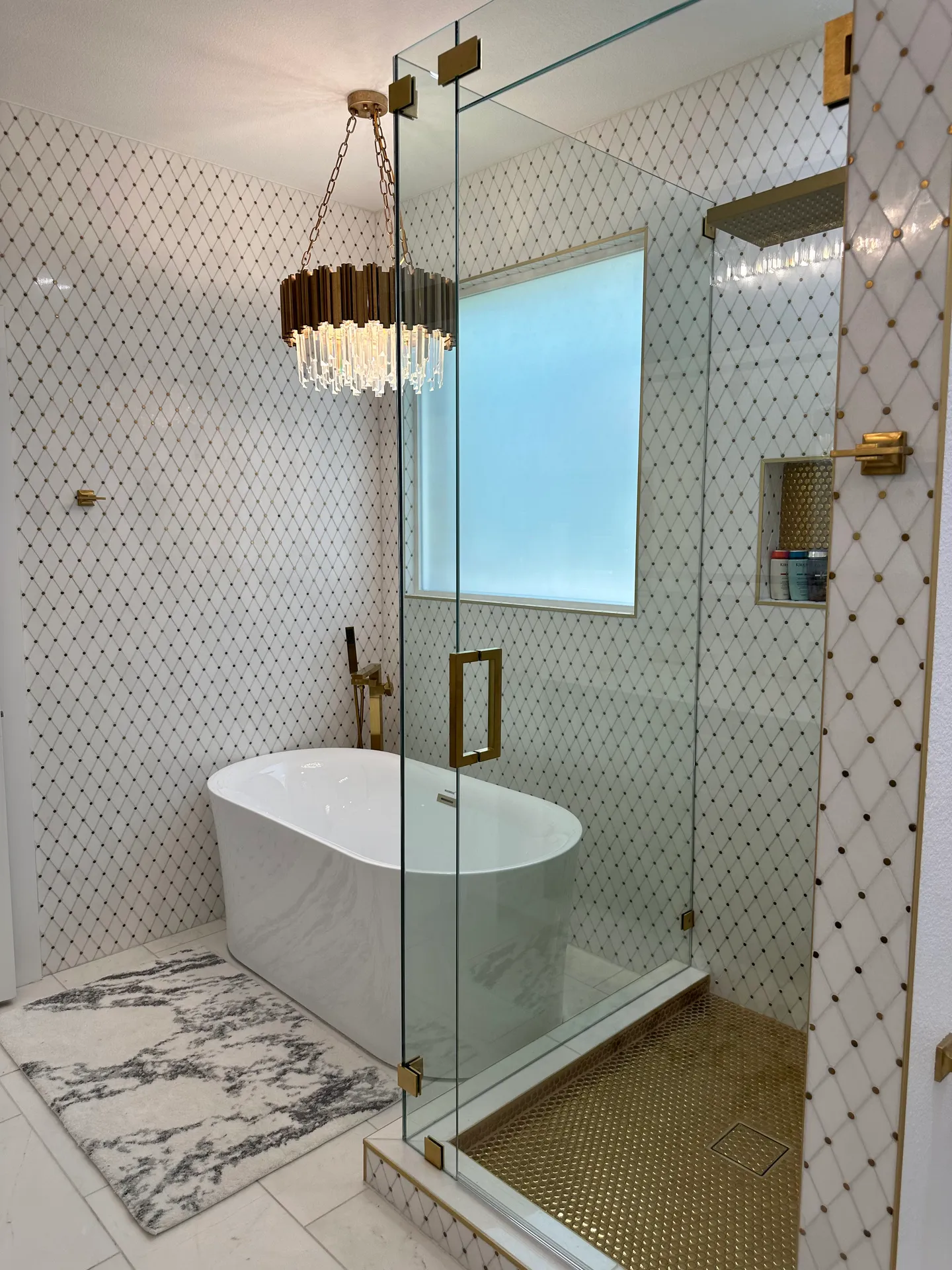 Frameless glass shower with patterned tile and freestanding tub
