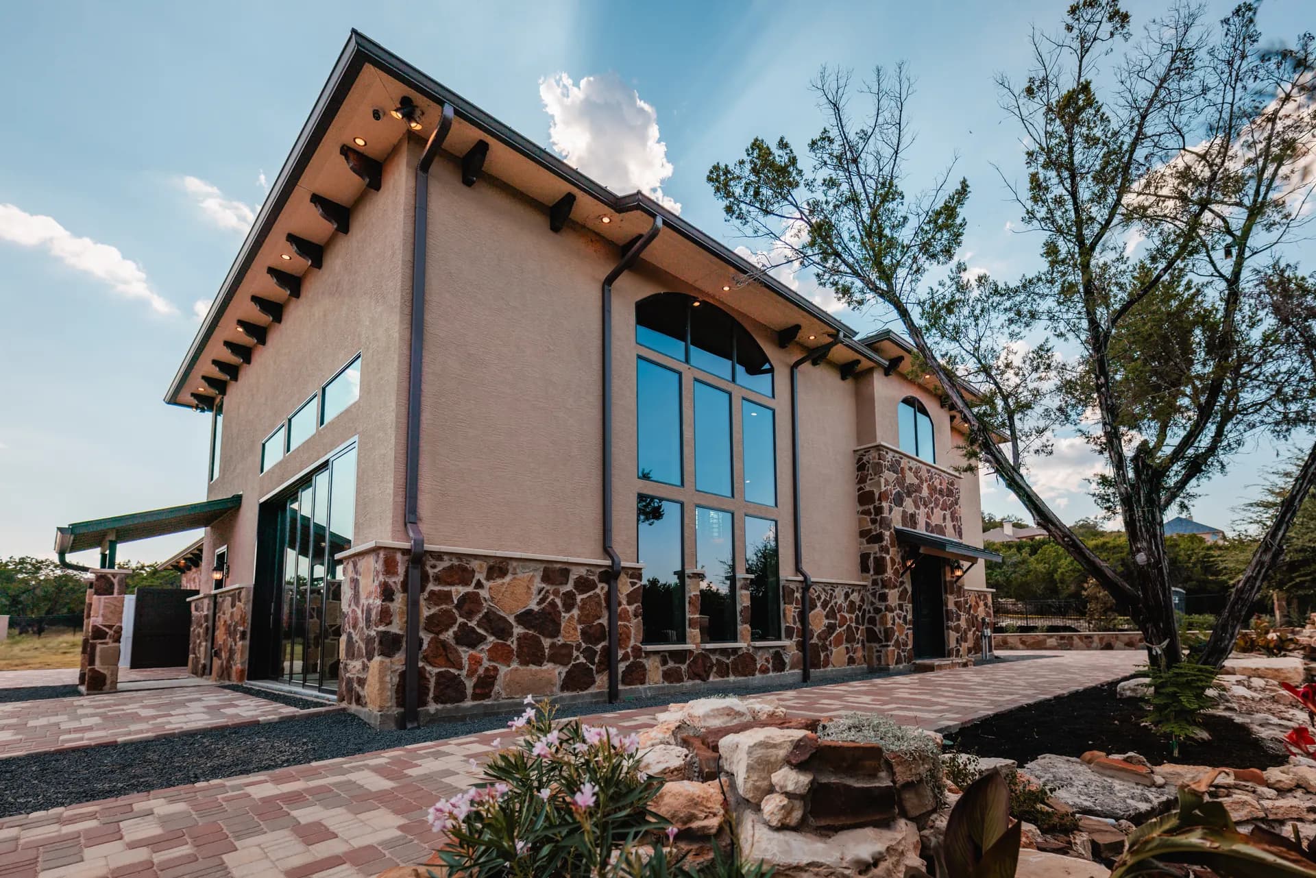 Gable end, arched window wall, and landscaped approach of the completed project