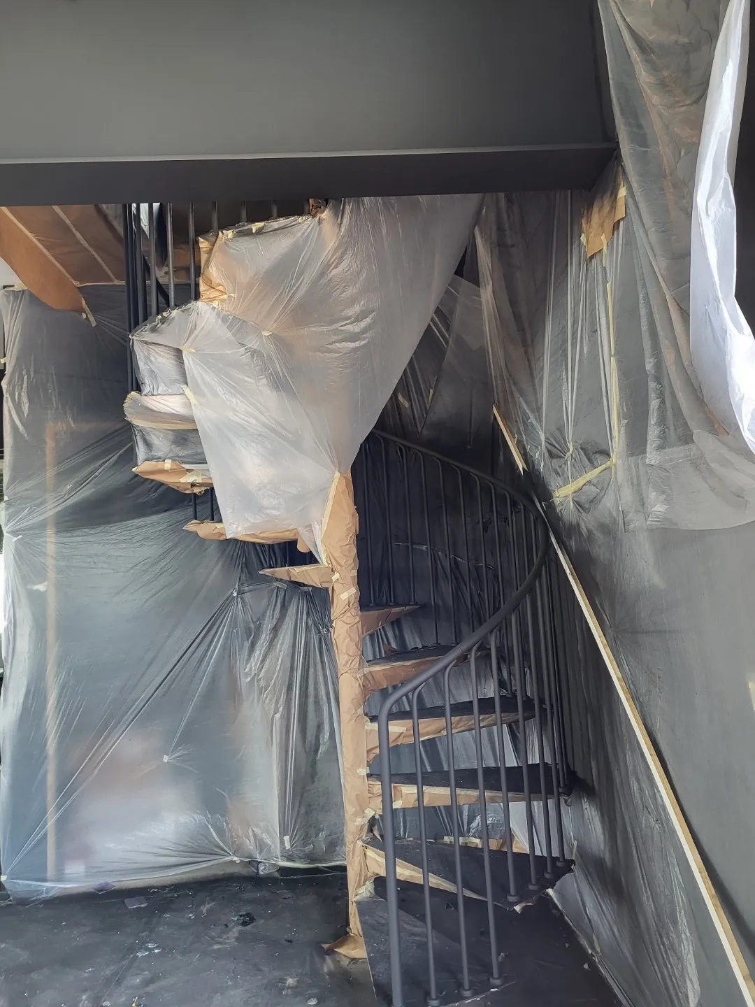 The spiral stair protected in plastic during construction