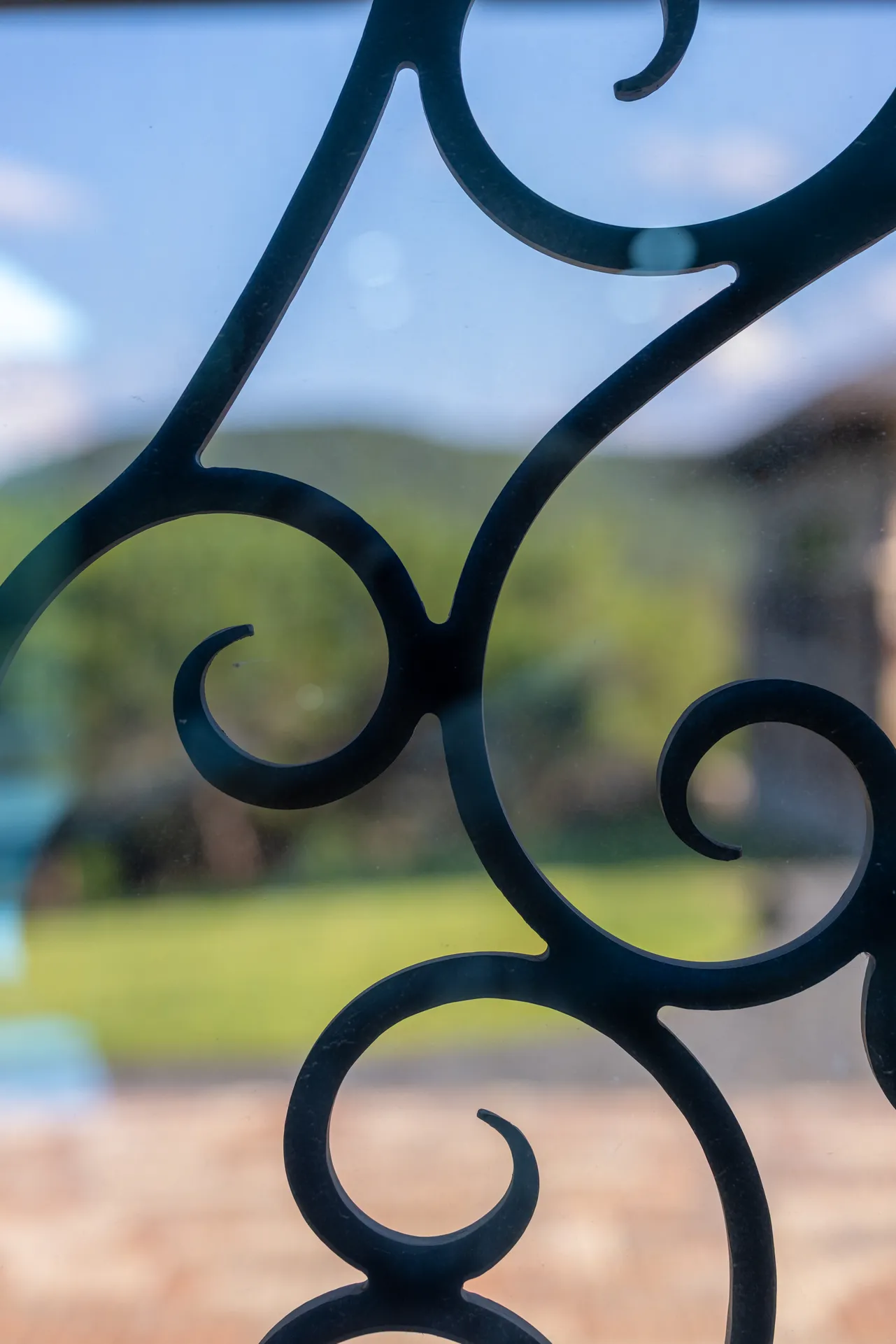 Close view of scrollwork set against glass at the entry