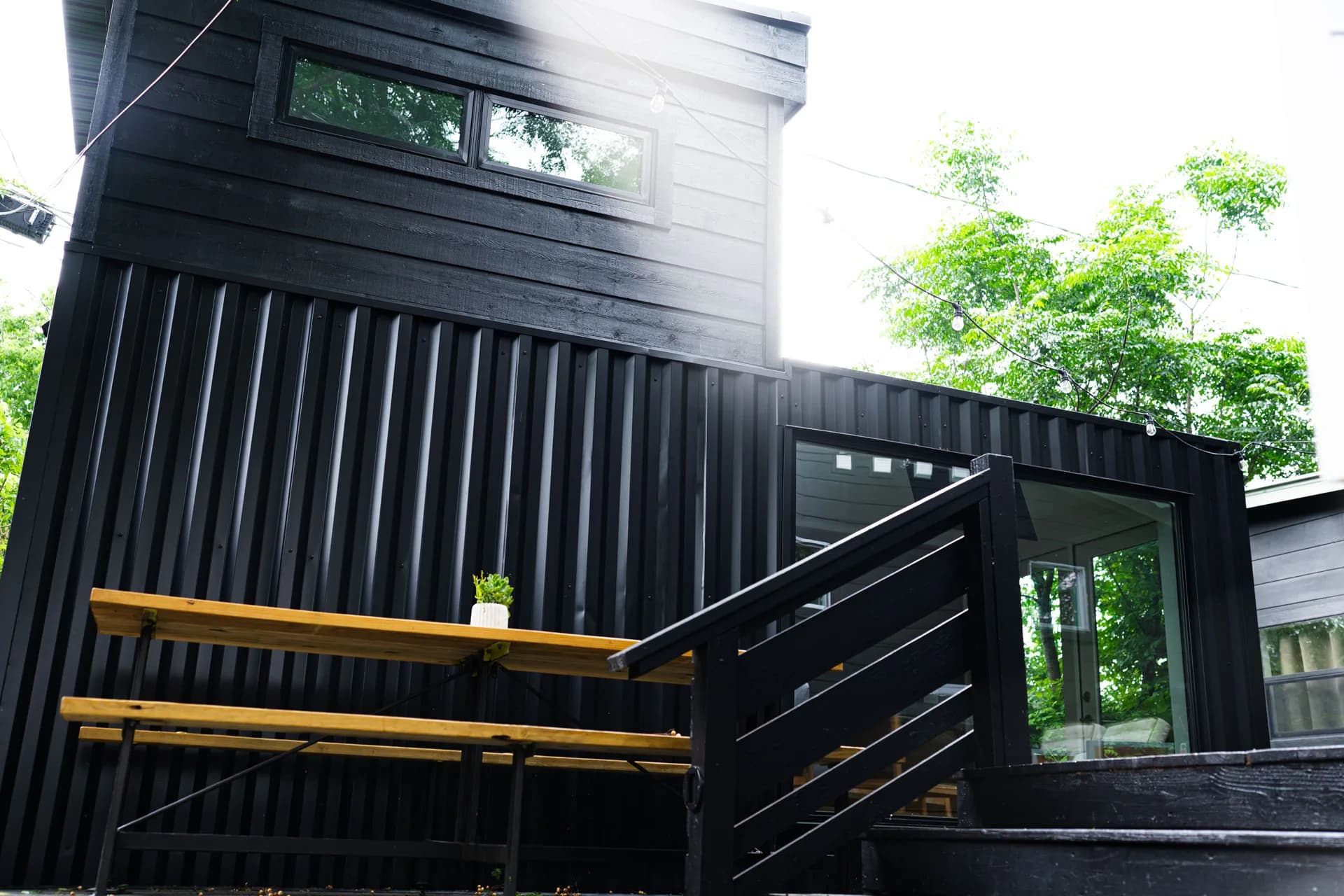 Dark container exterior, elevated terrace, and stairs at Domain’s East Austin ADU